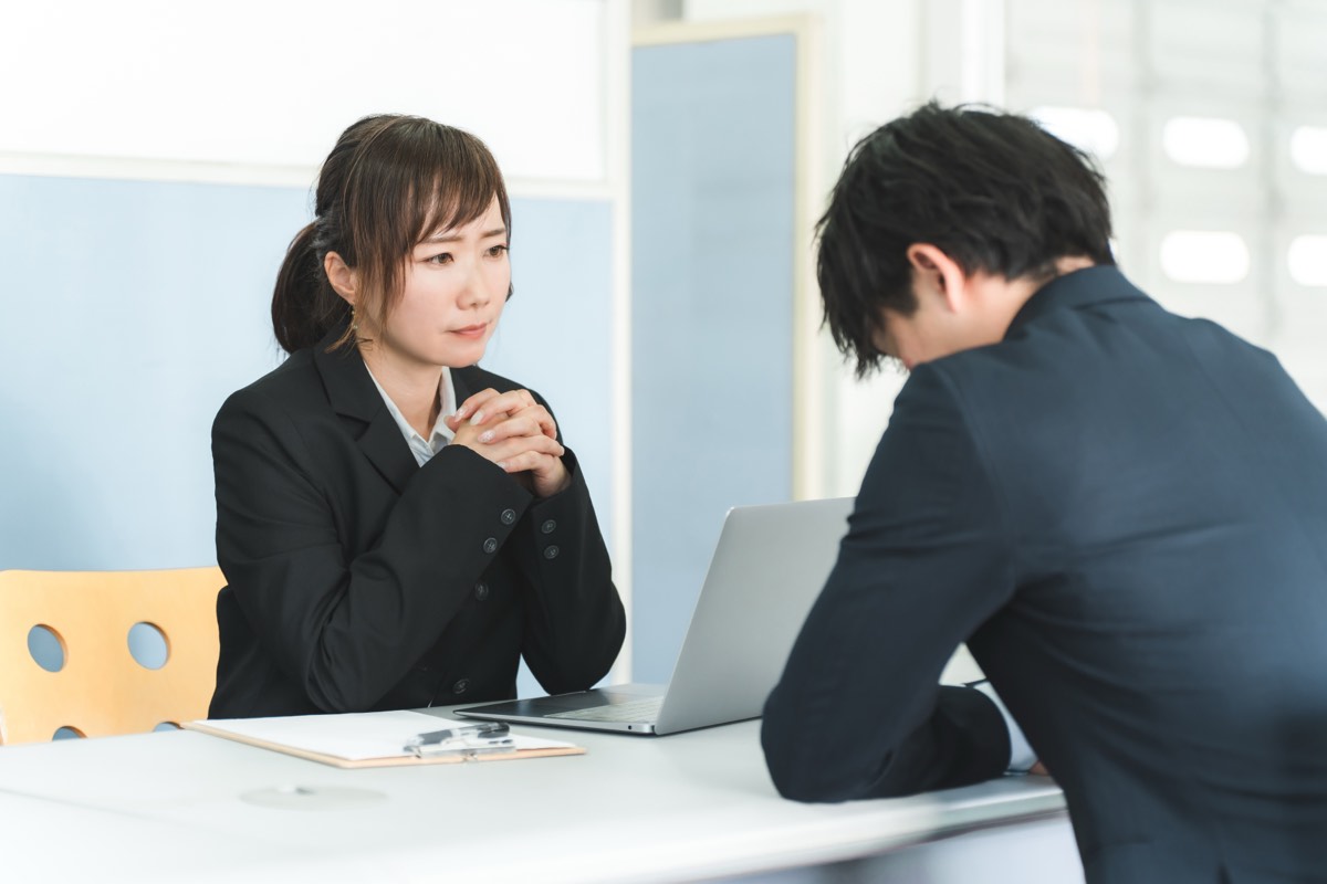 面談で若い社員と向き合う管理職の女性