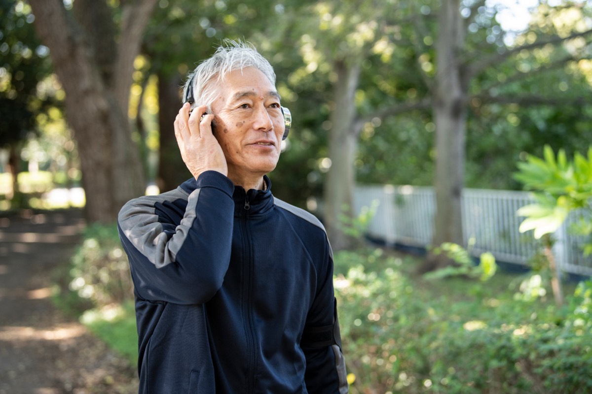 【要約】賢者の書|喜多川泰が9人の賢者に託した教えと、54歳の再読メモ 賢者の書の要約をAudibleで聴く。公園でヘッドフォンを使う男性