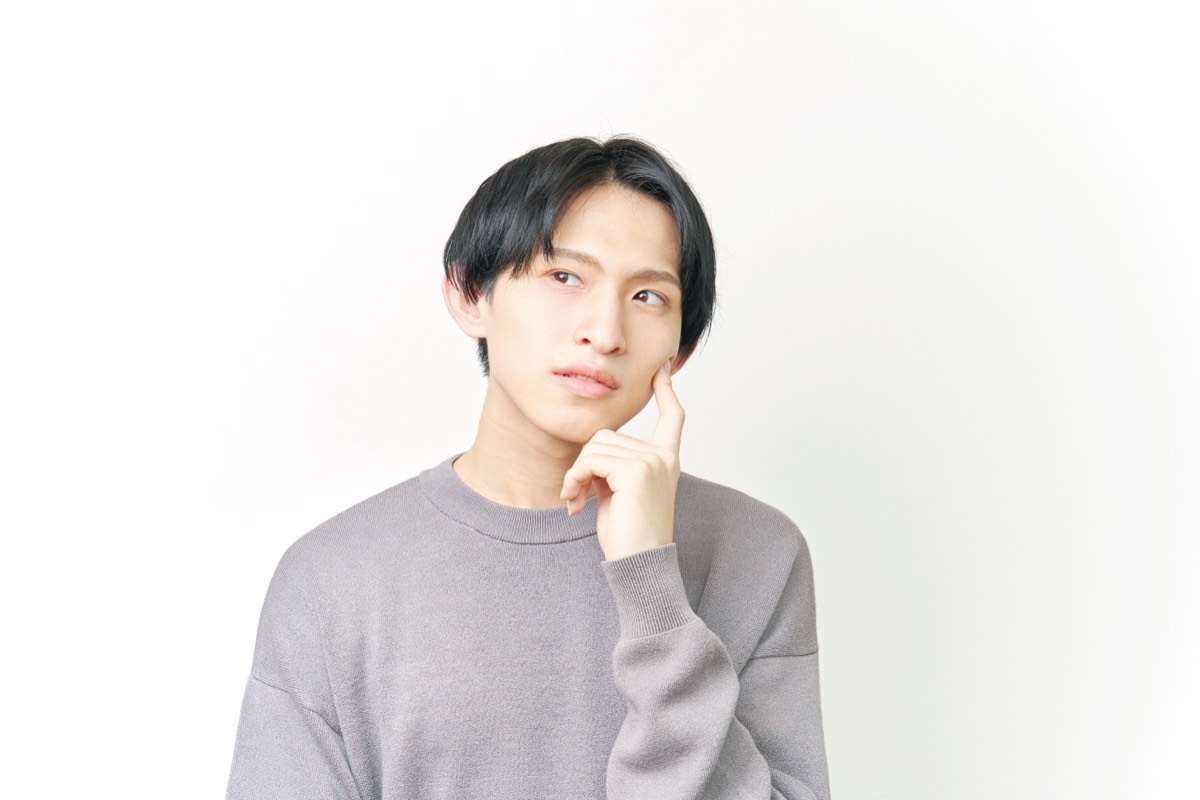 【要約】手紙屋(喜多川泰)|十通の手紙が教える「働く意味」を図解9点で 頬に手を当てて考え込む若い男性。手紙屋の要約における適職探しの教えのイメージ。