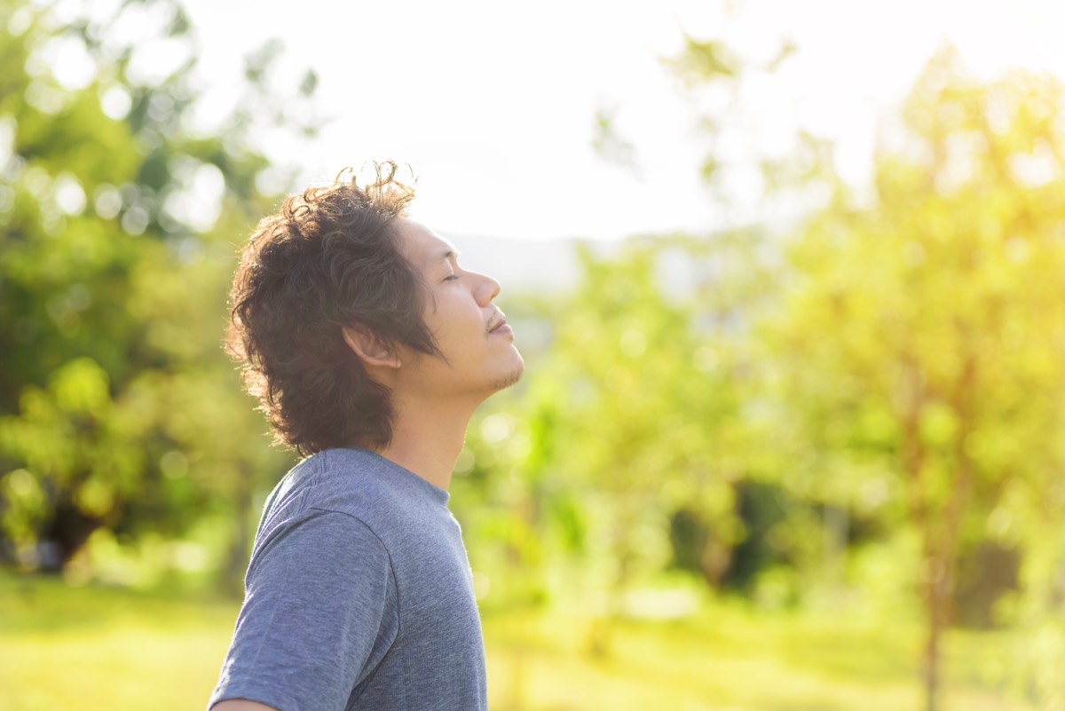1日誰とも話さない日に深呼吸をする男性