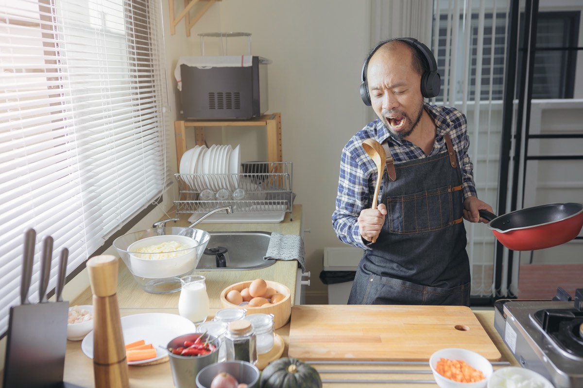 台所で鼻歌をうたいながら料理をする男性。1日誰とも話さない日に声を出す方法