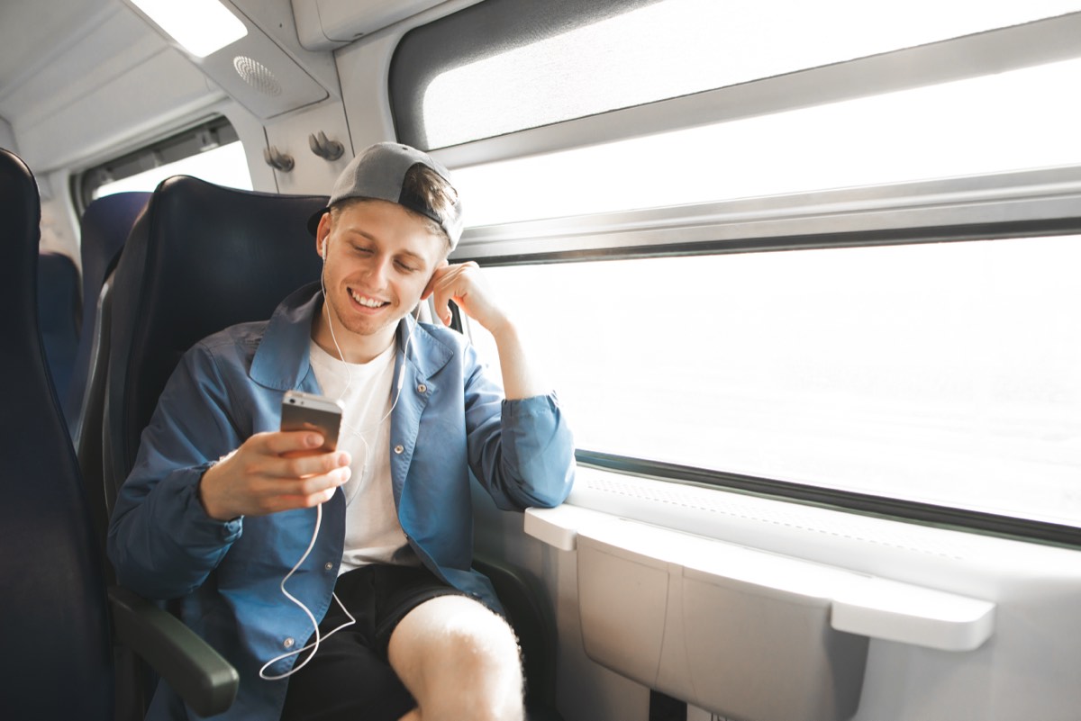 電車の座席でイヤホンを使って音声を聴く人。脱力のすすめの要約で扱うAudible版