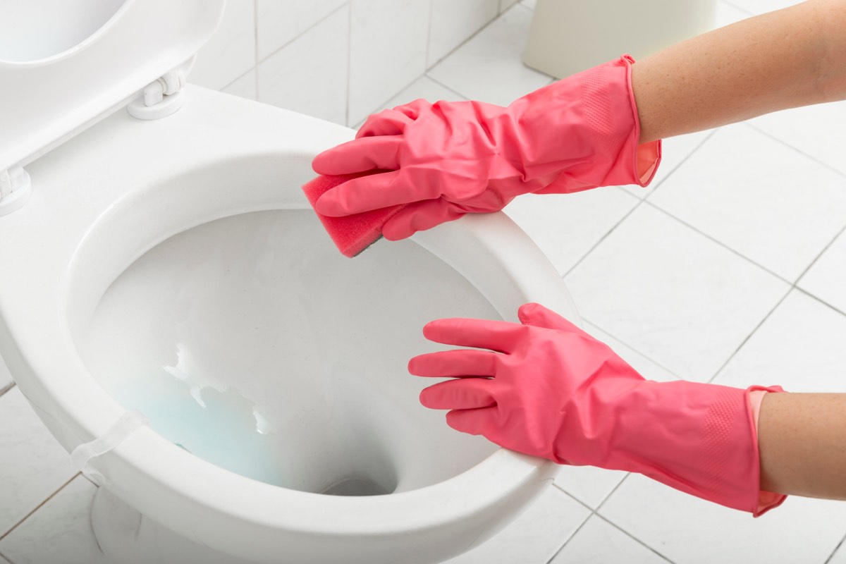 ゴム手袋をしてトイレの便器を掃除している手元。開運はおうちが8割の要約で金運がトイレに対応する場面