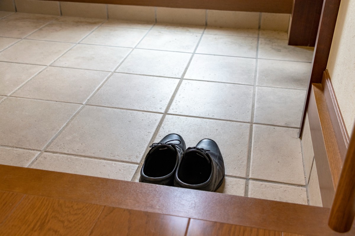 玄関のたたきに置かれた一足の黒い革靴。開運はおうちが8割の要約で靴が口の中に対応する場面