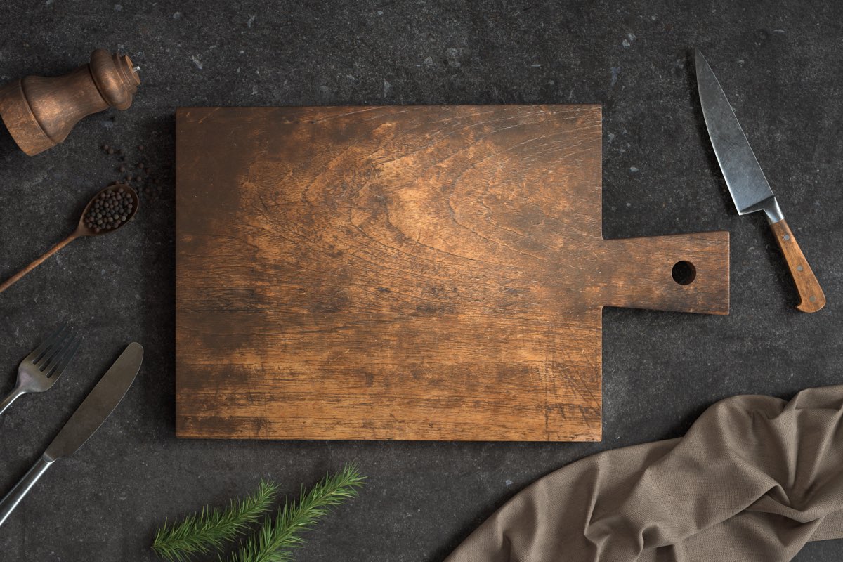 コンクリートの台に置かれた古い木のまな板と台所道具。開運はおうちが8割の要約でプロローグの題「なぜ、まな板を替えると運が良くなるのか」に当たる場面