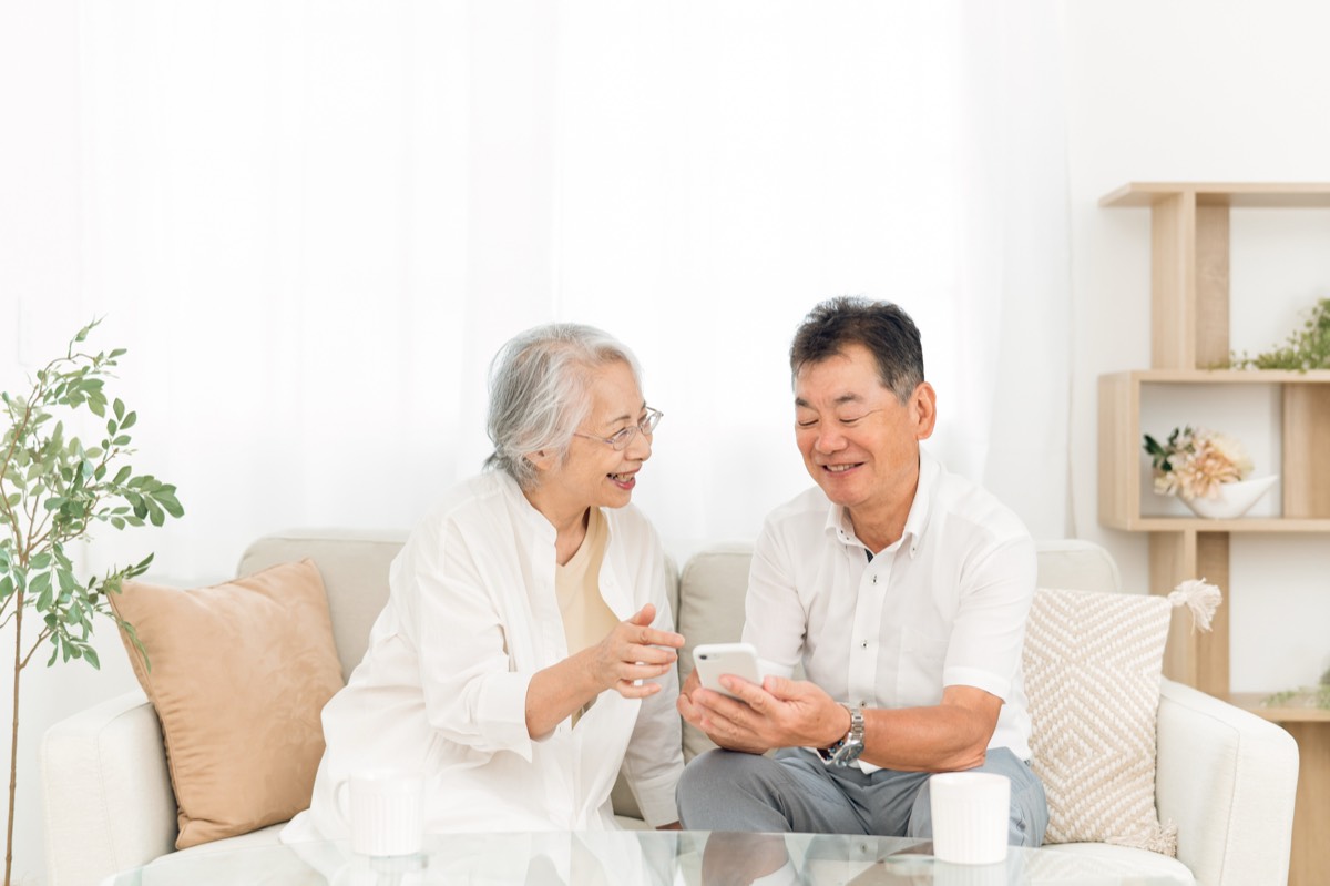 スマホを見て笑顔の高齢の夫婦
