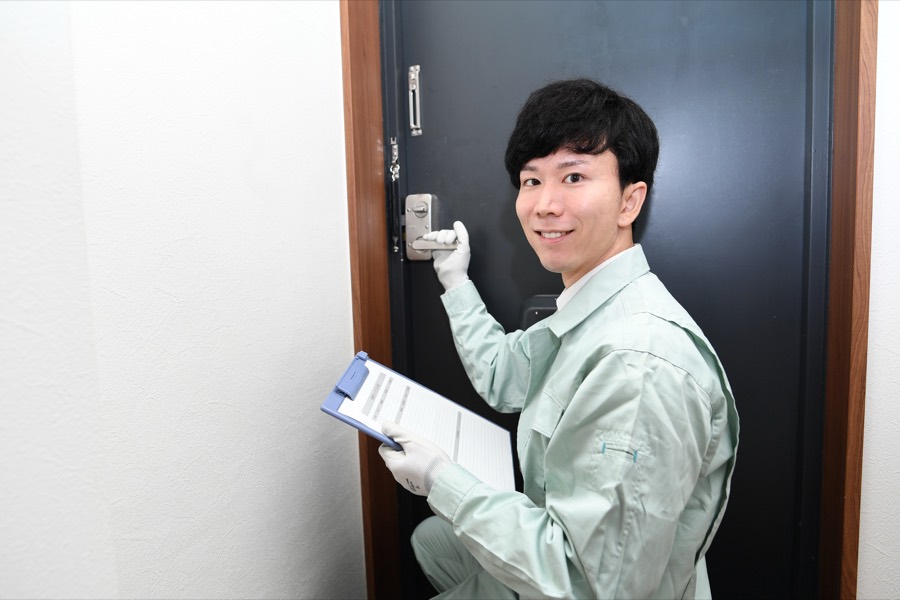 玄関ドアの鍵を修理する作業員