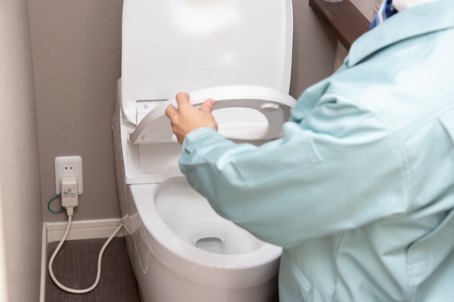 水回りの修理・交換 トイレを点検する作業着の男性