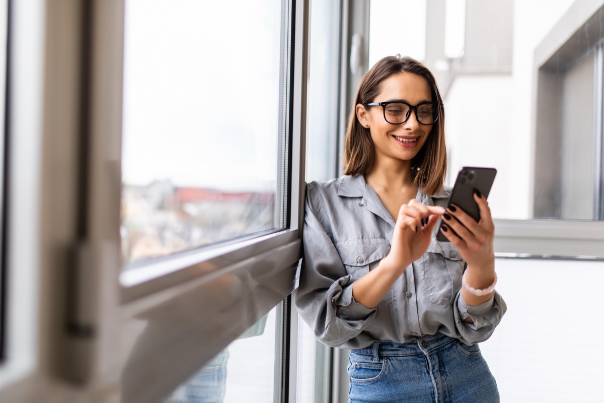年賀状の無料テンプレートで作った画像をスマホで送る女性