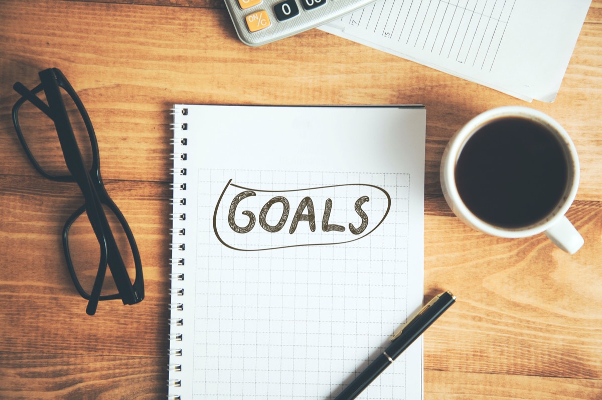 コーヒーとGOALSと書かれたメモ帳。目標を自分の言葉で書く