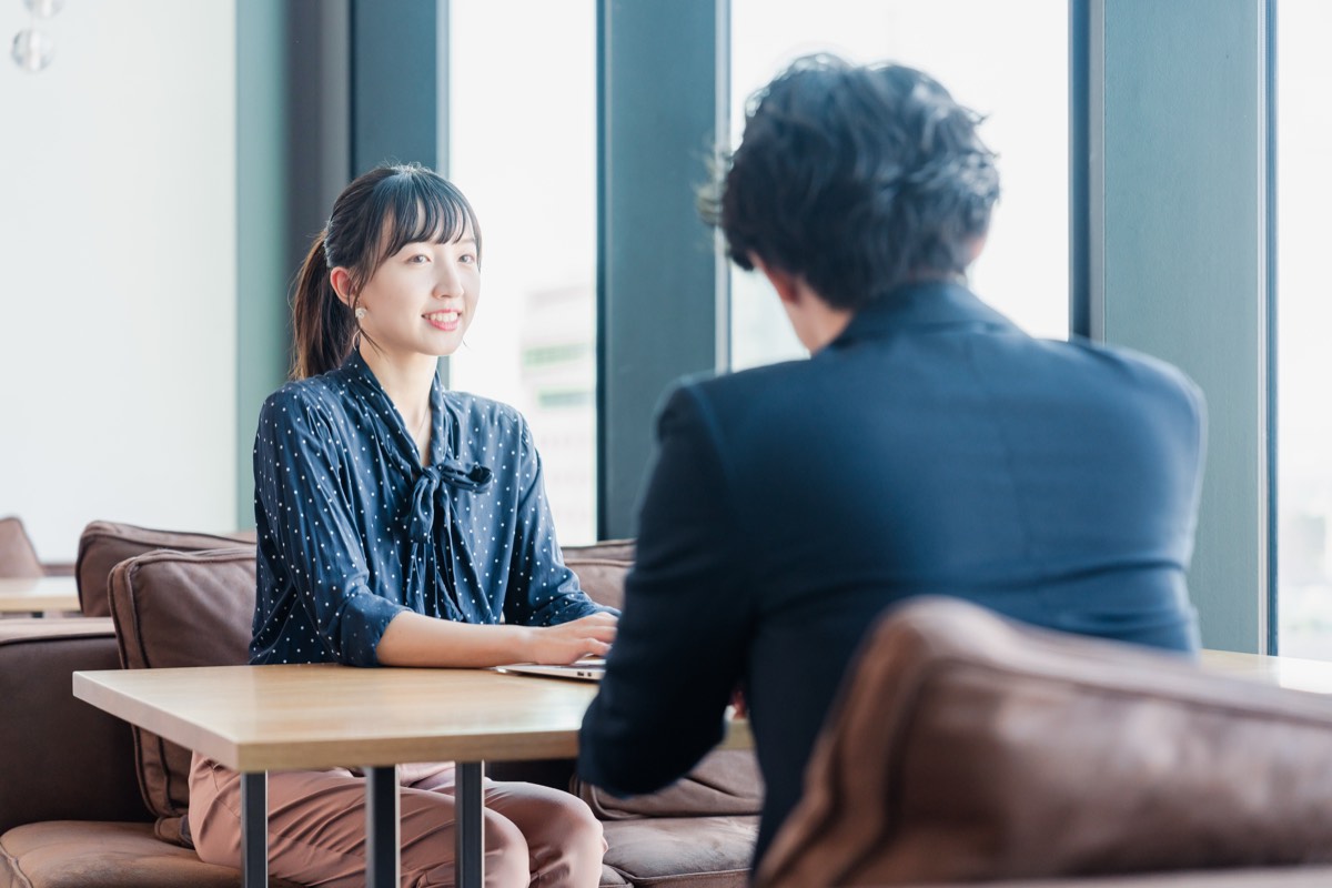 上司と1on1ミーティングで話す女性社員。指示待ち部下に答えを言わずに聴く場面