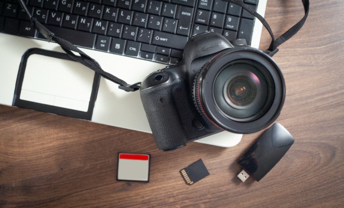 一眼レフカメラとノートパソコン。Adobe Stockに作品をアップロードする準備