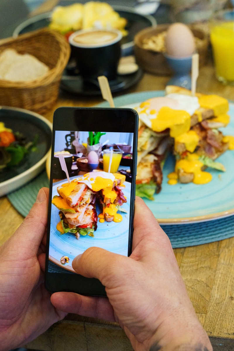 スマートフォンで料理の写真を撮る手元。Adobe Stockの審査では技術的な品質が見られる
