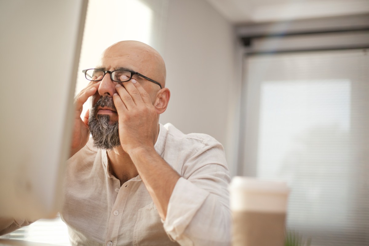 目頭を押さえる50代の男性。物覚えが悪くなったと感じる場面のイメージ