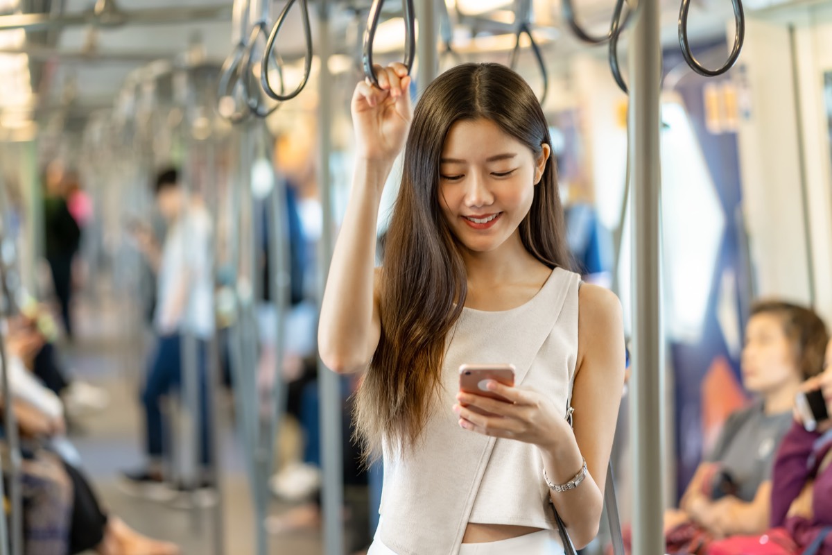電車でスマホを見る女性