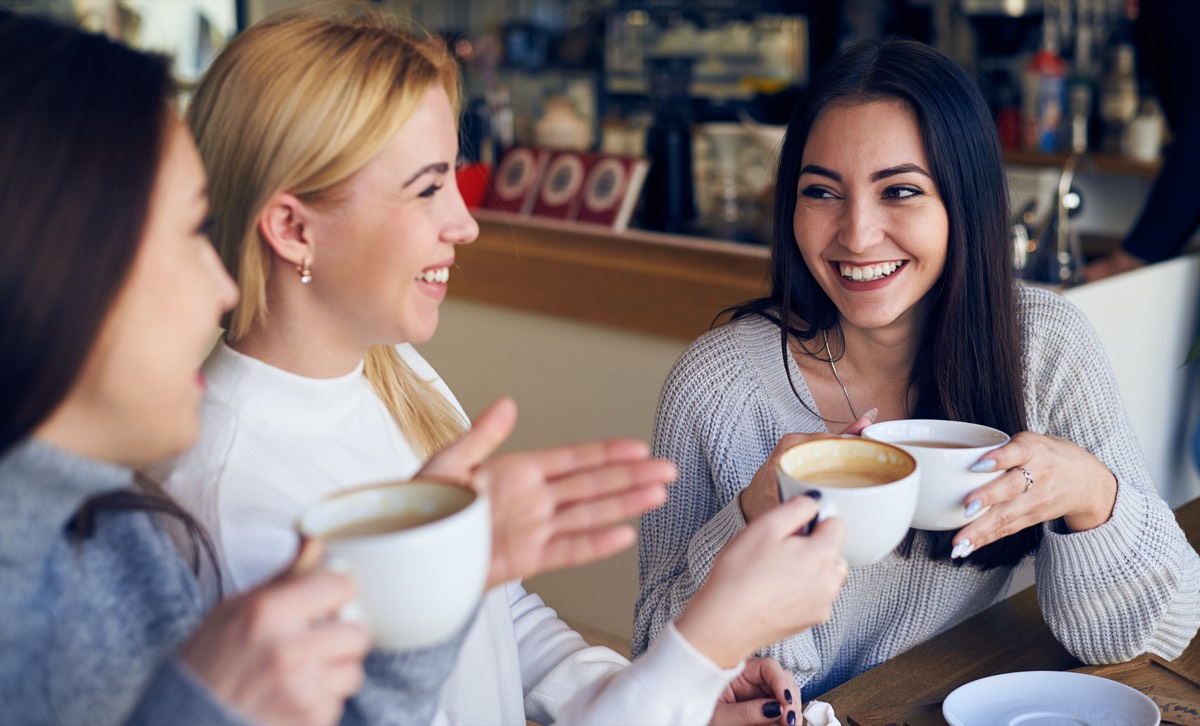 カフェで友人と笑いながら話す人たち。新しい人と知り合うことも脳への刺激
