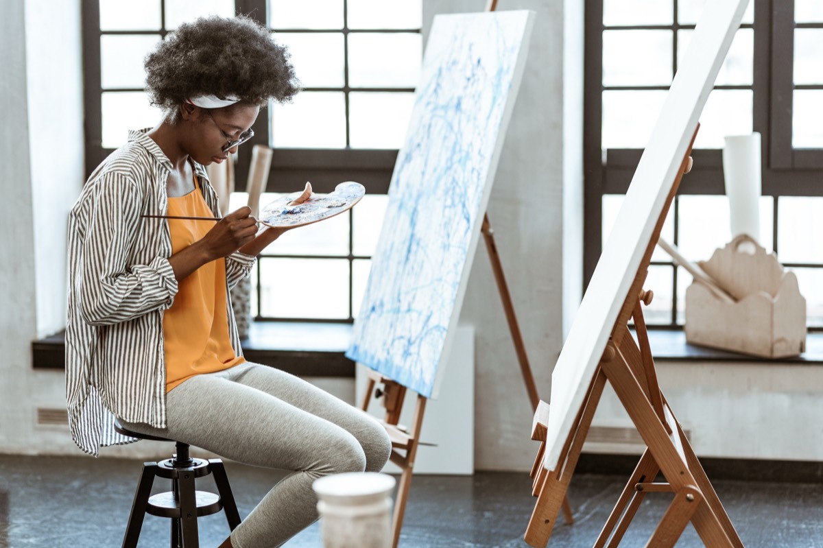 イーゼルに向かって絵を描く女性。50代から新しい趣味を始めるイメージ